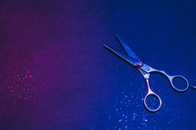 Hairdressing Scissors In Neon Light On A Dark Background. The Tool Of The Hairdresser..