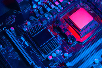 Hardware technology concept in neon light. Motherboard in blue-red light. Computer  component. Dark photo..