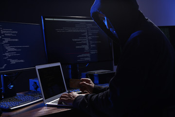 Hacker with computers and credit card in dark room. Cyber crime