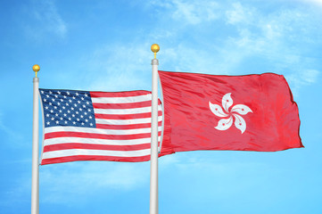 United States and Hong Kong two flags on flagpoles and blue cloudy sky