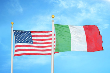 United States and Italy two flags on flagpoles and blue cloudy sky