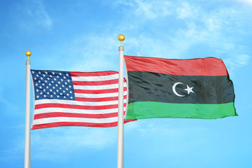 United States and Libya two flags on flagpoles and blue cloudy sky