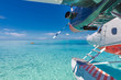 Amazing travel background in Maldives islands, seaplane floating on lagoon, blue sea. Exotic travel background, summer vacation concept