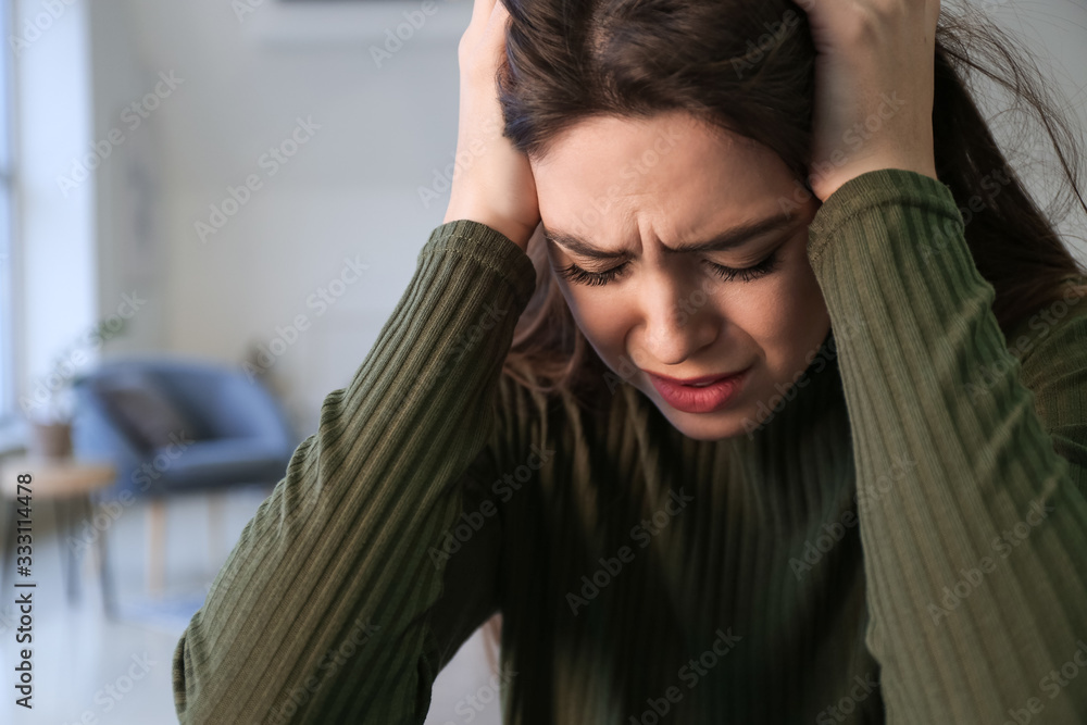 Depressed young woman at home