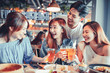 © Tom Wang - happy young group dining and drinking beer at restaurant