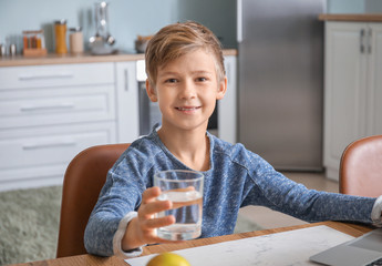 Wall Mural - Cute little boy drinking water in kitchen