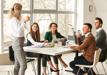 Female interior designer teaching young people in office