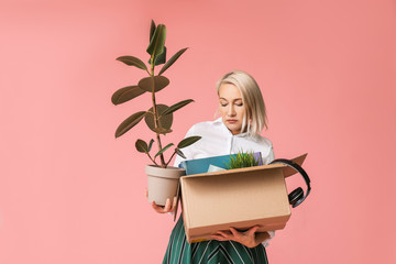 Wall Mural - Sad fired mature woman with personal stuff on color background