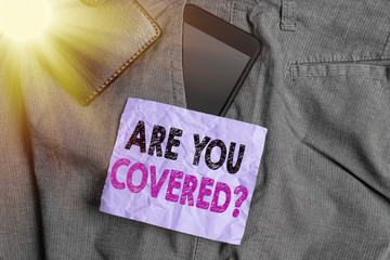 Word writing text Are You Covered Question. Business photo showcasing asking showing if they had insurance in work or life Smartphone device inside trousers front pocket with wallet and note paper