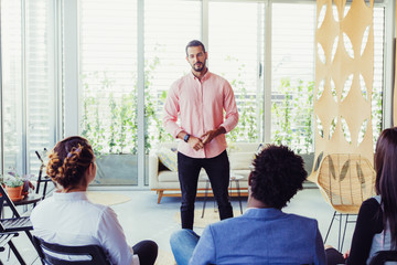 Confident male speaker holding seminar. Young entrepreneur in casual speaking before audience. Business training concept