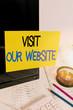 Text sign showing Visit Our Website. Business photo text visitor who arrives at web site and proceeds to browse Note paper taped to black computer screen near keyboard and stationary