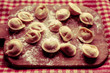 Raw pelmeni, dumplings of Russian and Eastern European cuisine on a board with fluor, ready to be boiled