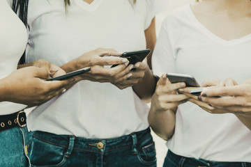 Closeup shot of female hands typing on smartphones. Cropped shot of young women using modern phones. Technology concept