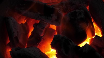 Wall Mural - slow motion speed closeup scene on burning charcoal pile with ash and flake of spark scattered blowi