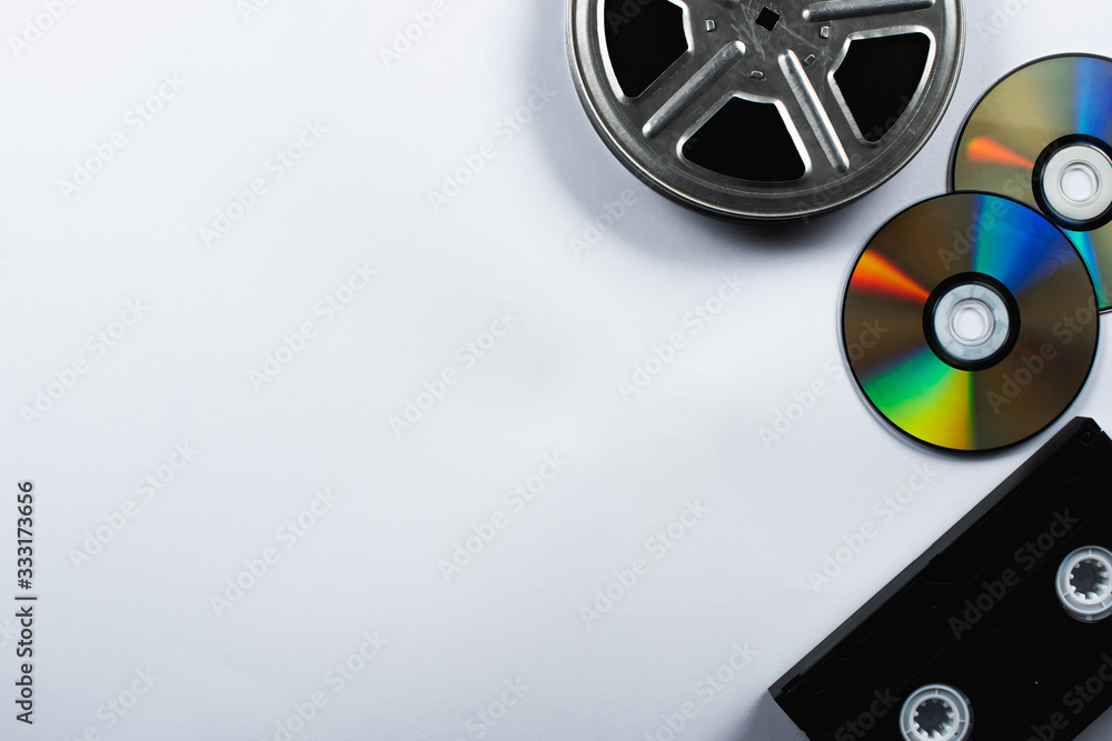 top view of CD discs, VHS cassette and film reel on white background - obrazy, fototapety, plakaty 