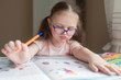© Kiryakova Anna - Happy pretty child girls sitting at the table and writes. Educational activities at home. Distance learning. Girl with glasses. Vision problems