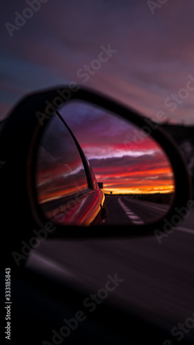 Fotomural Sunset in a car mirror on a long spanish road