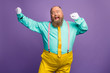 Portrait of funky crazy excited fat overweight man enjoy party discotheque dancing raise fists white gloves wear bright outfit isolated over violet color background