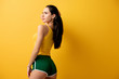 attractive girl standing in green shorts on yellow