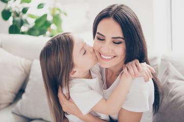 Sticker - Closeup photo of pretty little girl kissing cheek young charming attractive mommy hugging holding each other close sitting comfy sofa spend time together home house indoors