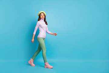 Poster - Full length profile photo of pretty tourist lady walk street abroad traveler wear green beret purple turtleneck jumper pants boots isolated blue color background