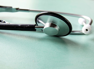 Stethoscope on a turquoise table, medicine. Treatment concept