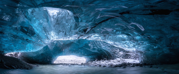 Wall Mural - Inside an ice cave in Vatnajokull, Iceland, the ice is thousands of years old and so packed it is harder than steel and crystal clear. Winter travel around the world.  Beautiful landscape background