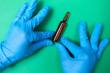 vaccine bottle in hands on a green background. Coronovirus Theme