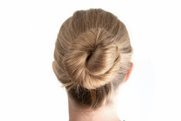 Simple bun hairstyle modeled by young white woman seen from behind close up shot isolated on white