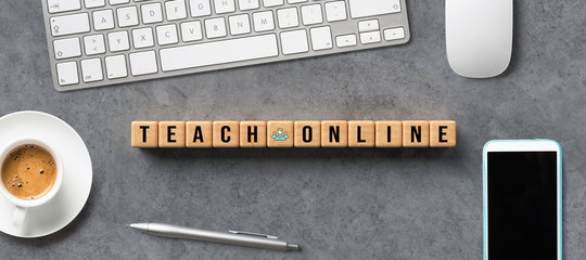 Wall Mural - cubes with message TEACH ONLINE and computer equipment on concrete background