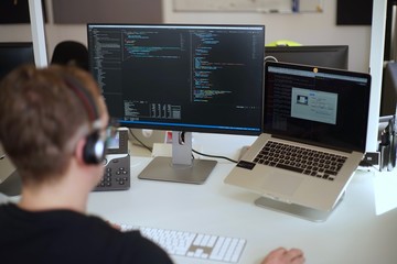 Real male web programmer coding javascript, php, symfony, react at work 