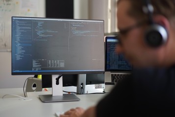 Real male web programmer coding javascript, php, symfony, react at work 