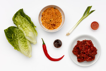 Fresh ingredients to make oriental beef lettuce cups, with vegetables and spices on a white background