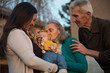 © Daniel - Happy grandparents enjoying with granddaughter outside