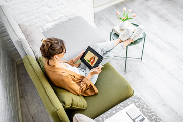 young creative woman working as a web designer or artist, drawing on a digital tablet while sitting 