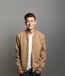 © Fotosushi - Portrait of smiling young man standing against gray background