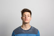 © Fotosushi - Portrait of young man standing against white background