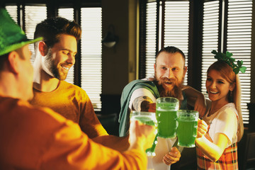 Sticker - Group of friends toasting with green beer in pub. St. Patrick's Day celebration