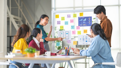 young asian woman leading business creative team in mobile application software design project. brai