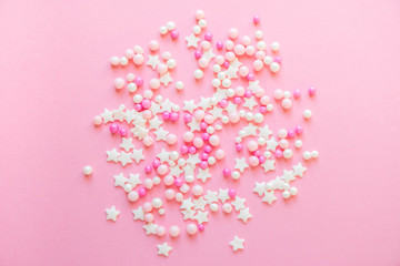 colorful pastel sprinkles on a pink background. sprinkle sugar with balls and stars, decoration for 