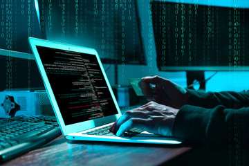 cyber criminal with credit card hacking system at table, digital binary code on background