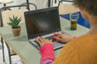 © Óscar - Back view of a young woman working on her laptop while having a drink in a coffee shop