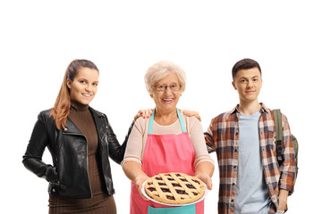 Poster - Young female and male standing next to an elderly woman holding a pie