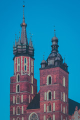 Sticker - Mariacka bazylika or St. Mary Basilica in Krakow, Poland in beautiful evening light. Visible red brick towers and blue sky.