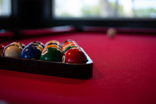 A Closeup View Of Billiard Balls On A Red Felt Pool Table.