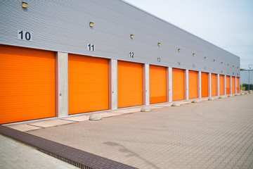 Wall Mural - small business units with orange roller doors