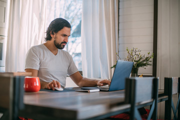 Workplace at home. A man works at a laptop at home