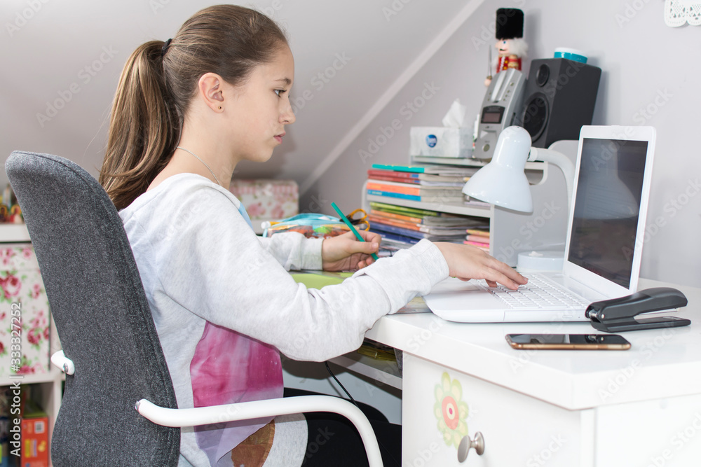 Dziewczynka pisze na laptopie zadanie - obrazy, fototapety, plakaty 
