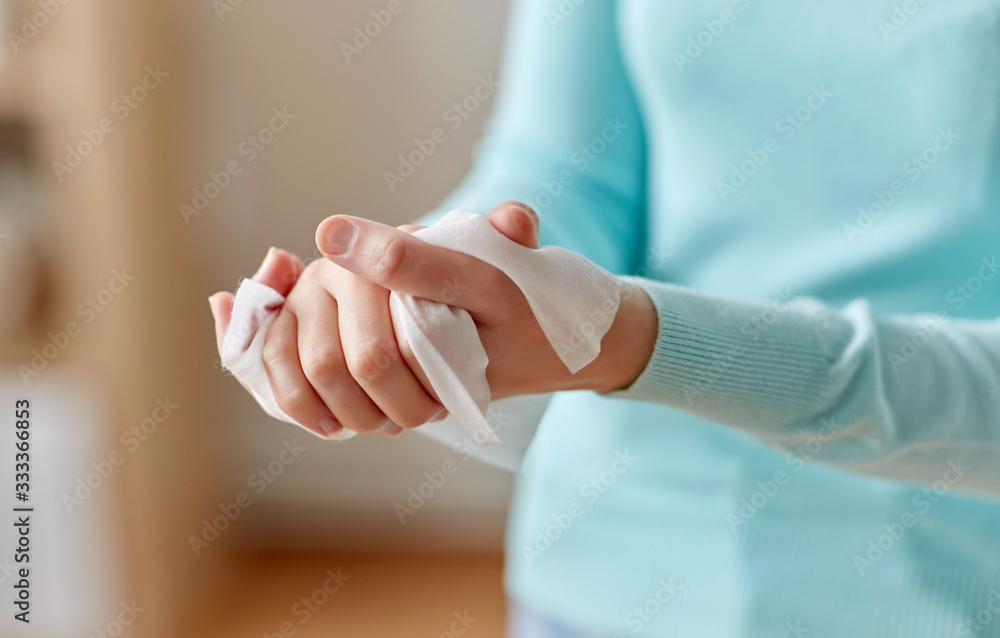 hygiene, health care and disinfection concept - close up of woman cleaning hands with antiseptic wet wipe - obrazy, fototapety, plakaty 