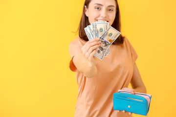 Poster - Young woman with wallet and money on color background